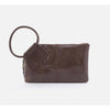 Brown leather clutch bag with a ring handle on a white background