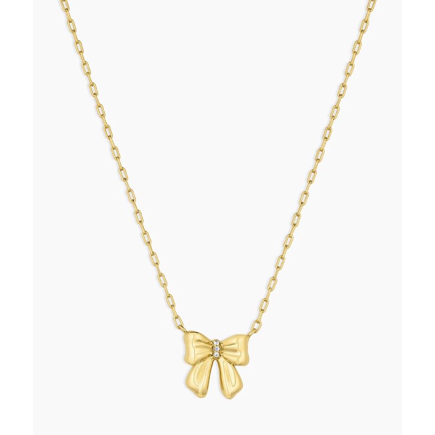 Gold bow-shaped pendant on a chain against a white background