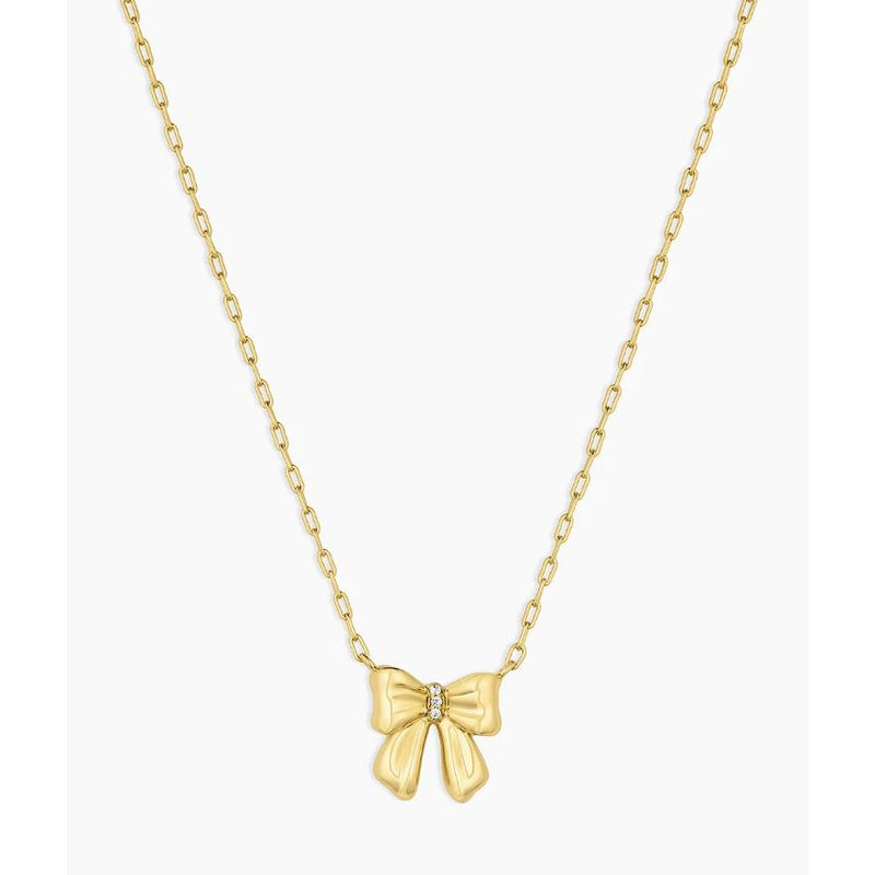 Gold bow-shaped pendant on a chain against a white background