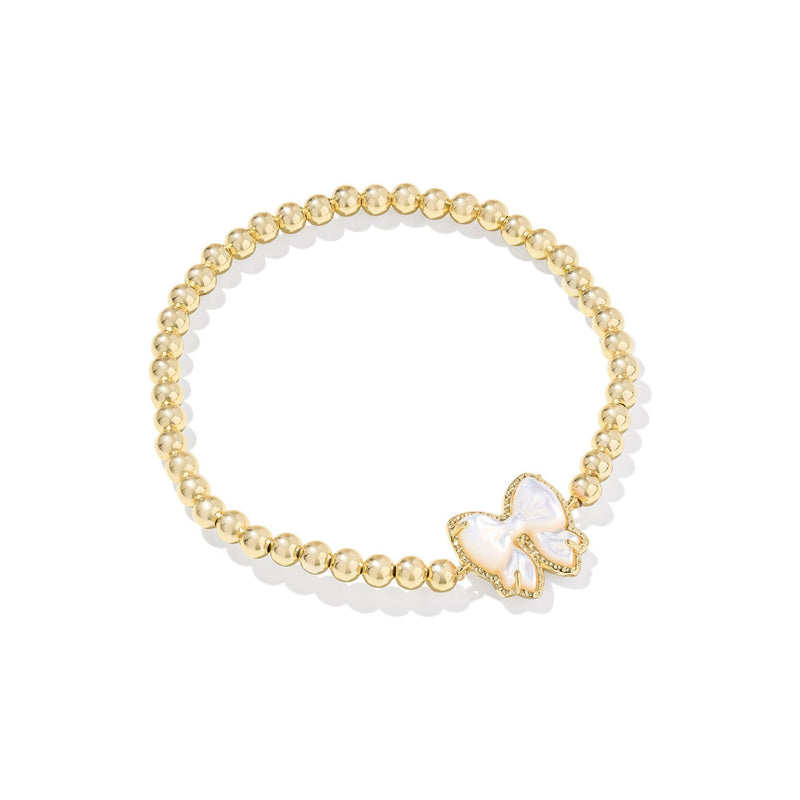 Gold beaded bracelet with a white butterfly charm on a white background