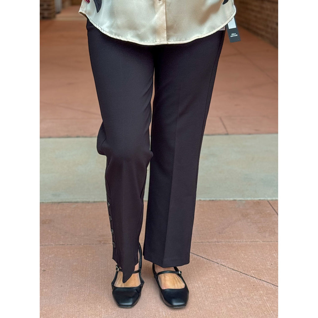 Person wearing black pants and a light-colored top on a tiled floor.