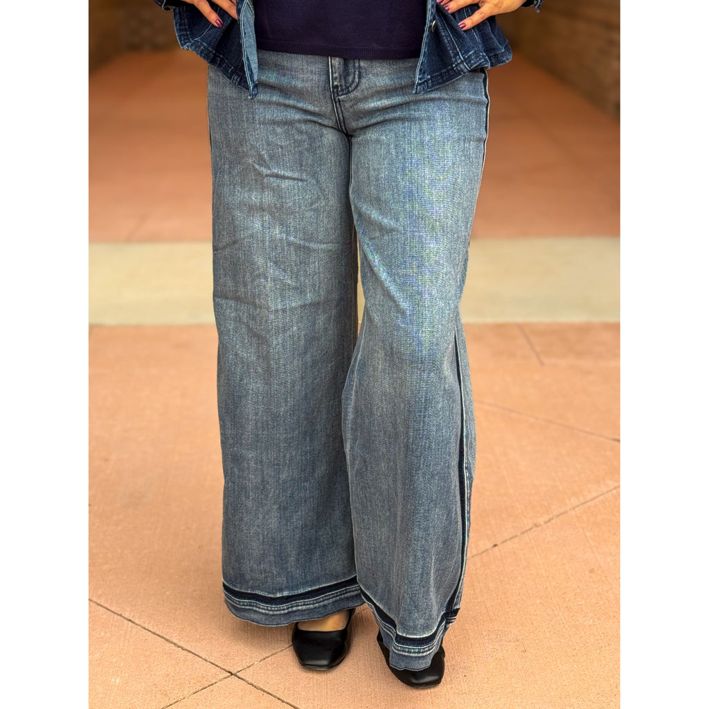 Person wearing blue jeans on a tiled floor